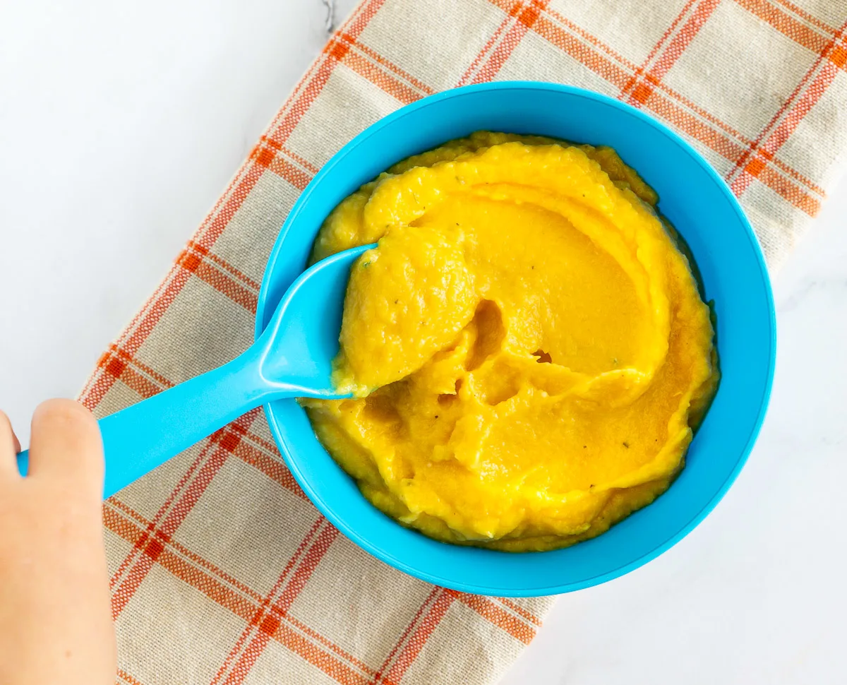 white bean butternut squash puree baby food in blue bowl with a blue spoon