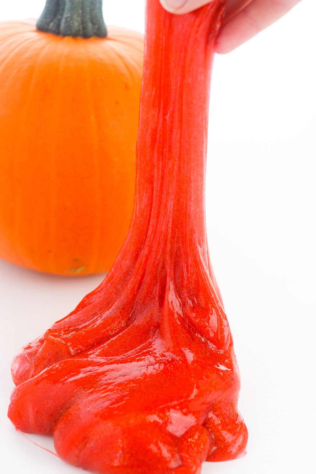 fall slime being stretched in front of a pumpkin
