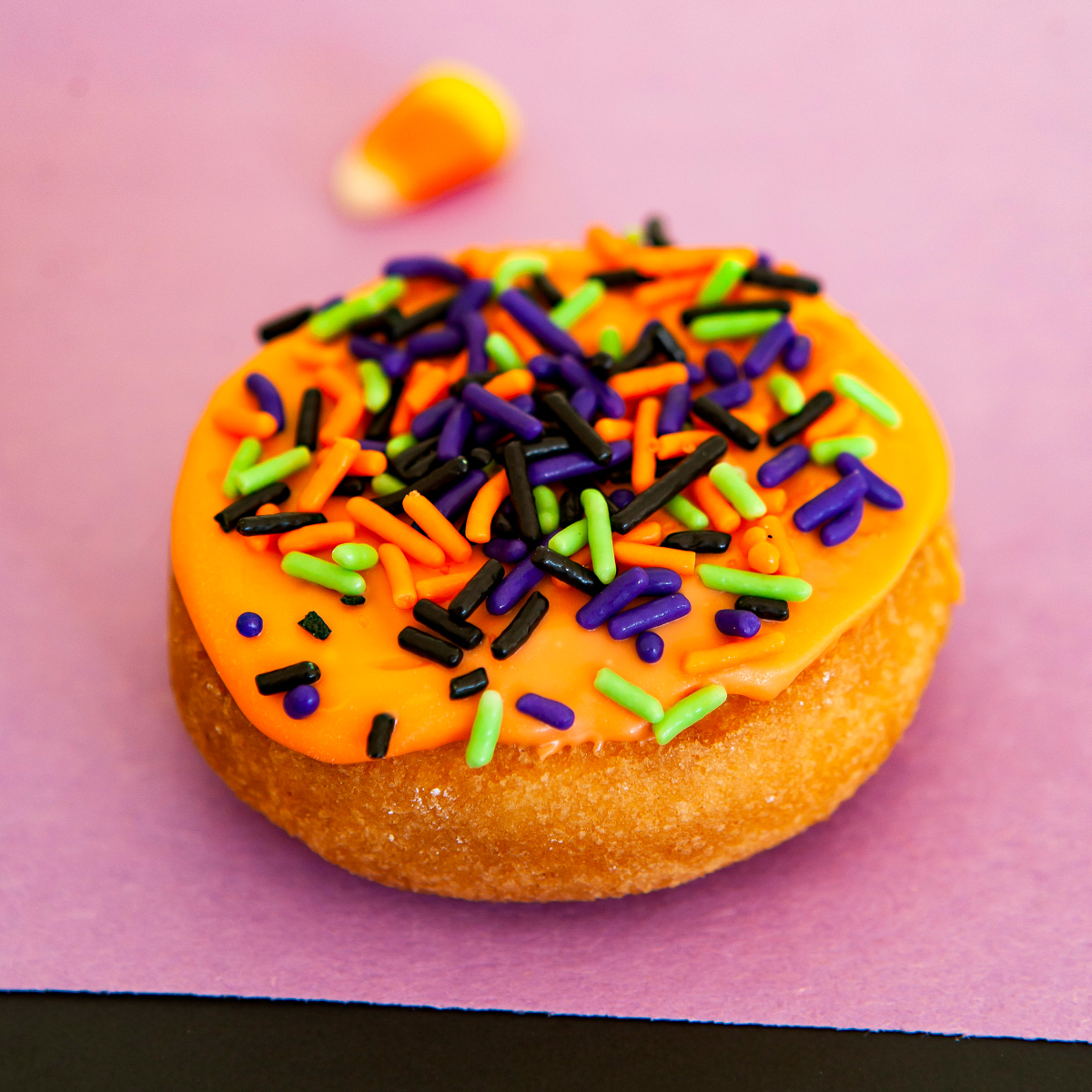 orange glazed donut with halloween sprinkles
