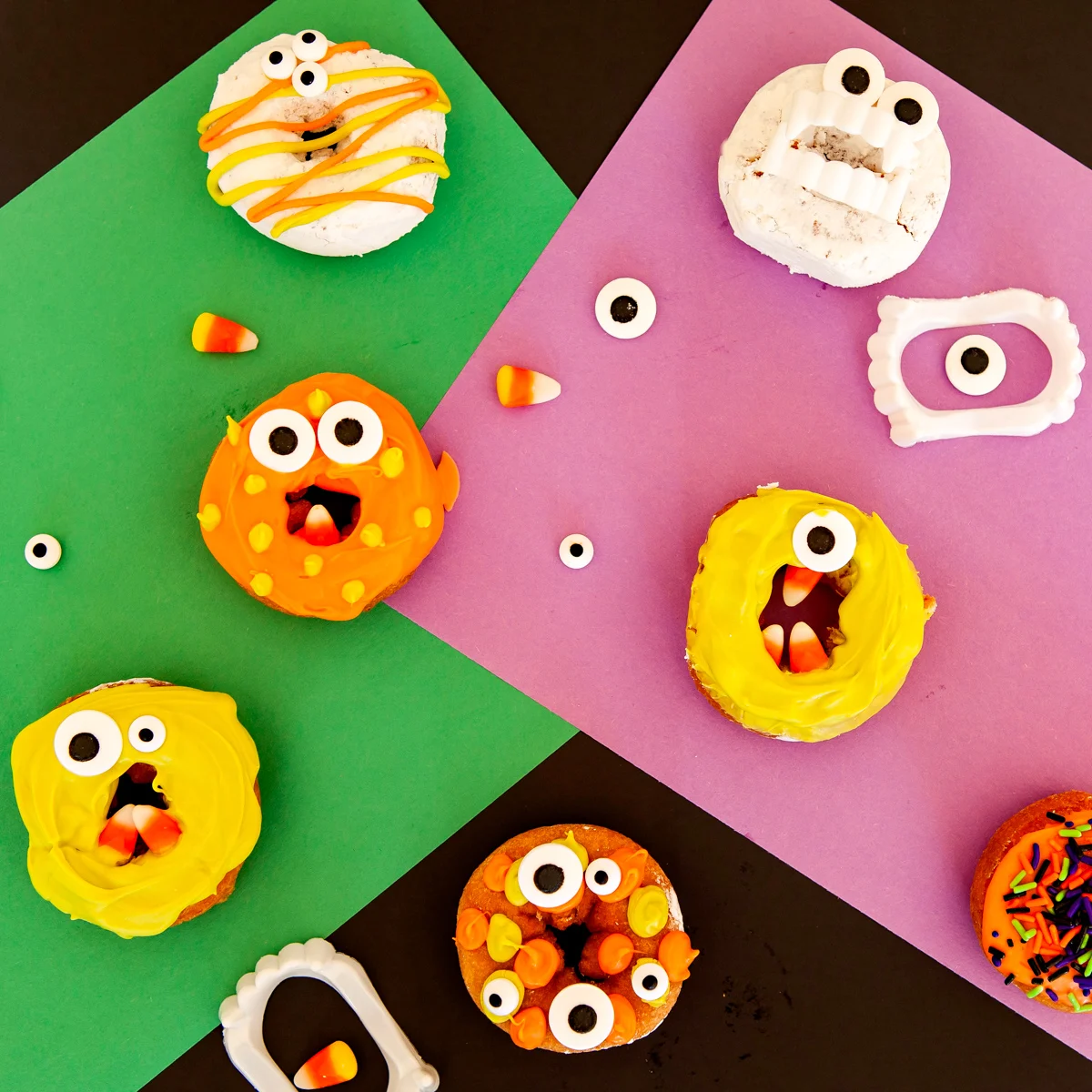overhead image of Halloween decorated donuts - monster donuts on colorful construction paper