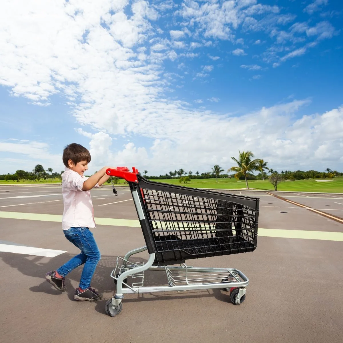 boy returning shopping cart in a parking lot