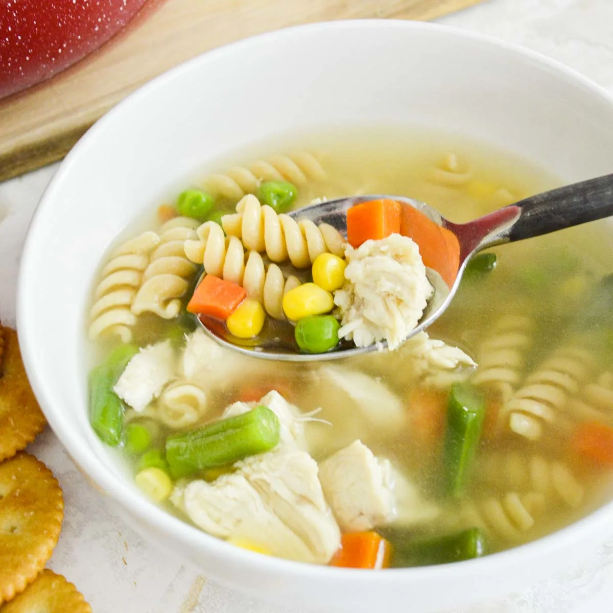 Spoon of chicken noodle soup with vegetables